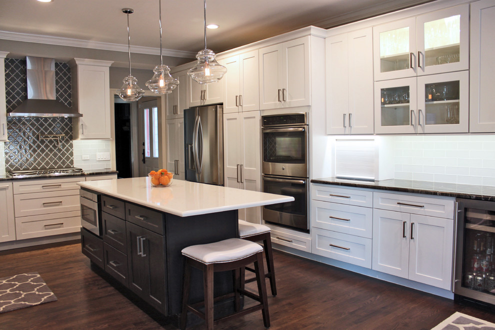Large contemporary u-shaped eat-in kitchen in Chicago with an undermount sink, shaker cabinets, white cabinets, granite benchtops, black splashback, glass tile splashback, stainless steel appliances, dark hardwood floors and multiple islands.