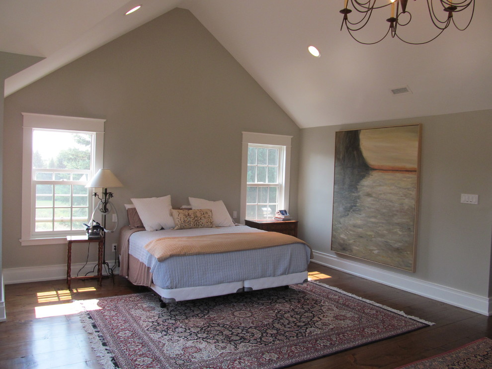 This is an example of a large country master bedroom in Toronto with medium hardwood floors, grey walls, brown floor, a standard fireplace and a tile fireplace surround.