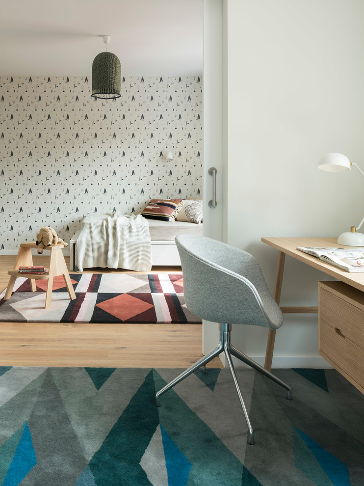 Mid-sized scandinavian gender-neutral kids' study room in Barcelona with multi-coloured walls and light hardwood floors for kids 4-10 years old.
