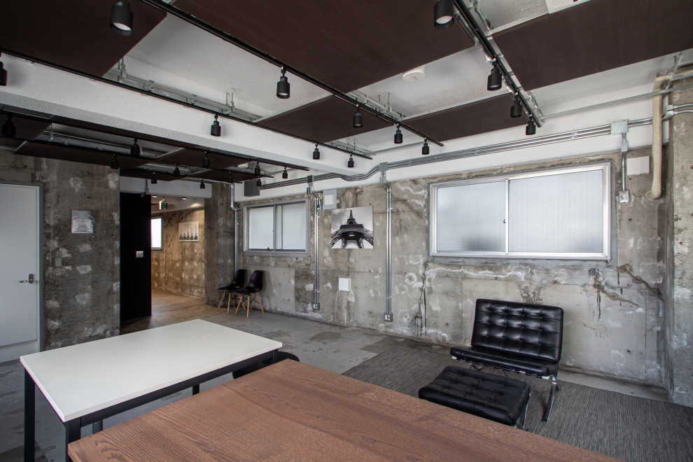 Mittelgroßes Industrial Arbeitszimmer ohne Kamin mit Studio, grauer Wandfarbe, Betonboden, freistehendem Schreibtisch, grauem Boden, Kassettendecke und Holzwänden in Sonstige