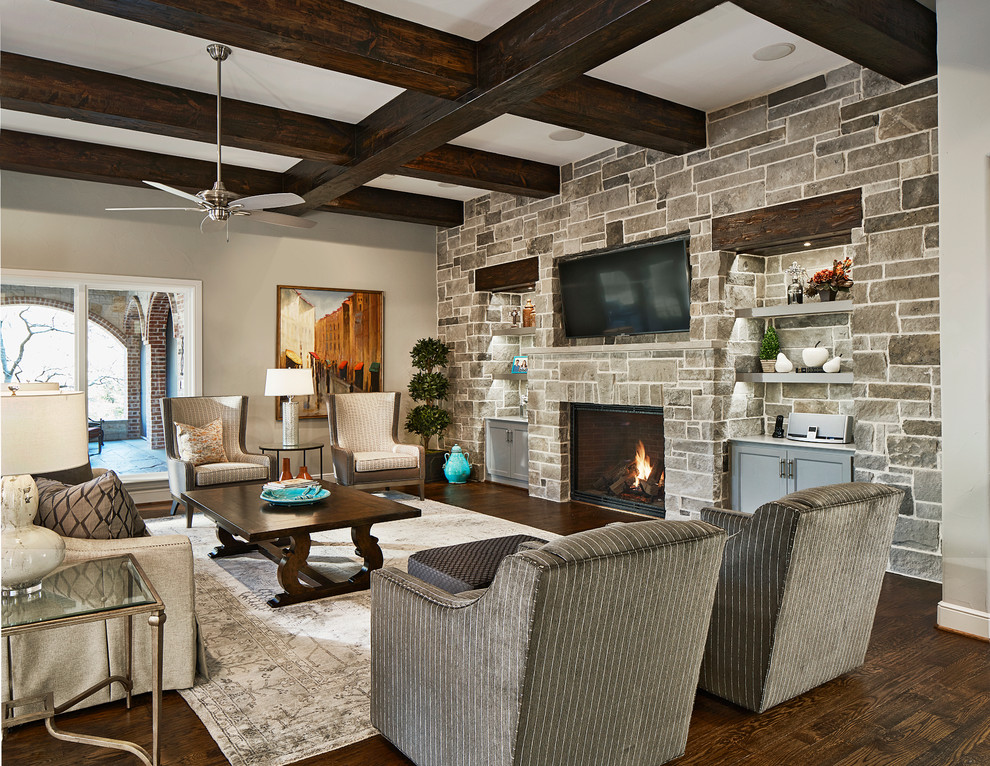 Photo of a large transitional family room in Dallas with grey walls, dark hardwood floors, a standard fireplace, a stone fireplace surround and a wall-mounted tv.