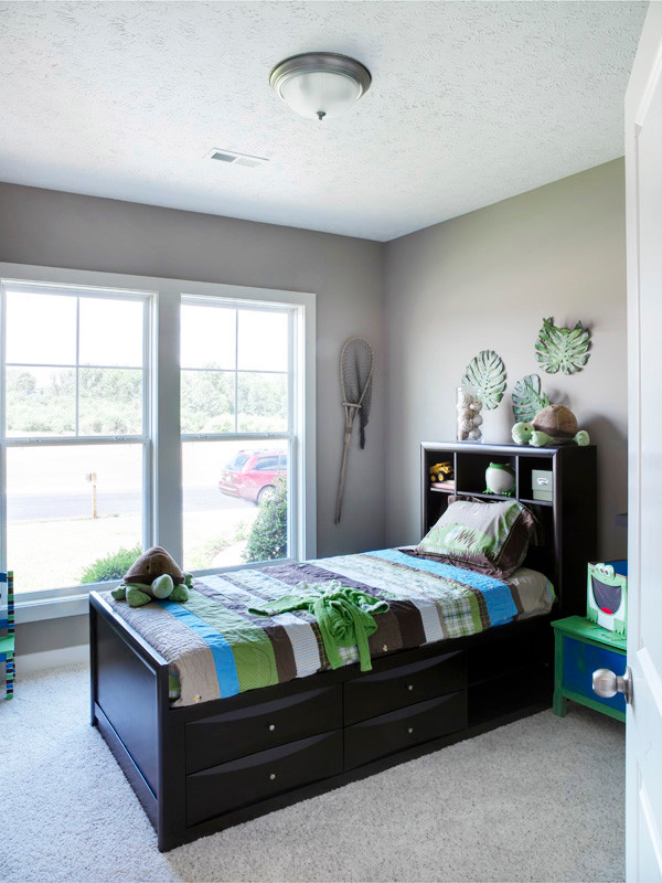 This is an example of a small transitional kids' bedroom for boys and kids 4-10 years old in Other with grey walls and carpet.