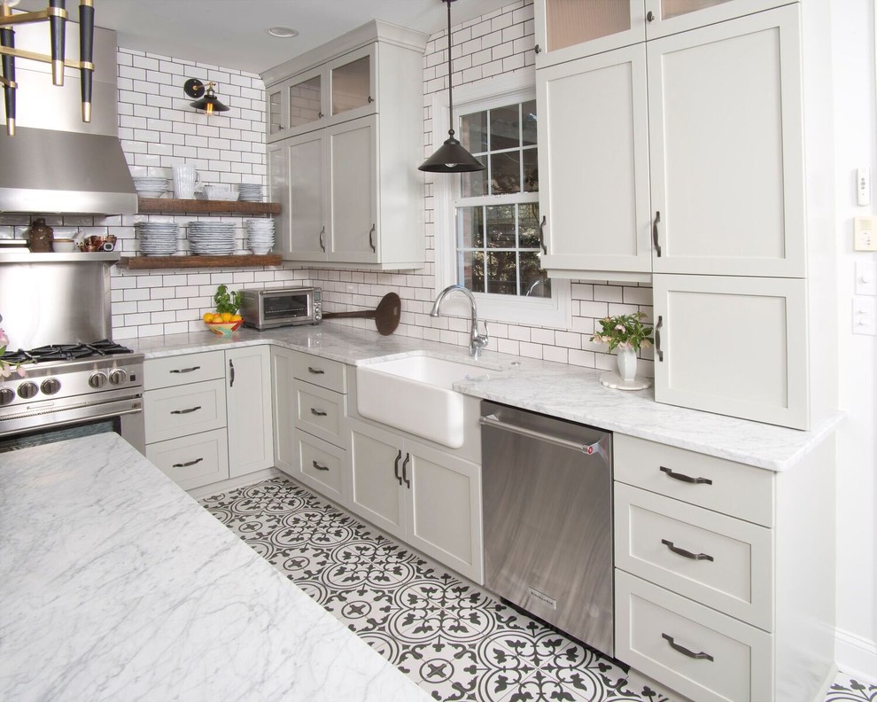 Example of a mid-sized transitional u-shaped ceramic tile and multicolored floor eat-in kitchen design with a farmhouse sink, shaker cabinets, marble countertops, white backsplash, subway tile backsplash, stainless steel appliances, an island and gray cabinets