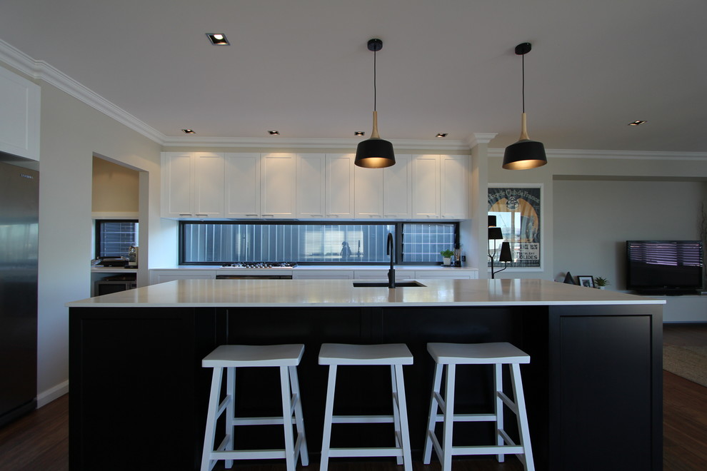 Photo of a mid-sized contemporary galley eat-in kitchen in Canberra - Queanbeyan with an undermount sink, recessed-panel cabinets, dark wood cabinets, quartz benchtops, stainless steel appliances, medium hardwood floors and with island.