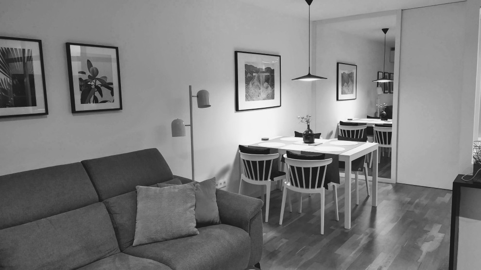 Cette photo montre une salle à manger ouverte sur le salon industrielle de taille moyenne avec un mur blanc, un sol en bois brun, une cheminée standard, un manteau de cheminée en métal et verrière.