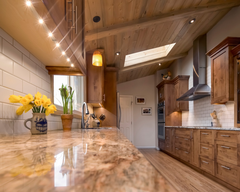 Inspiration for a transitional galley medium tone wood floor enclosed kitchen remodel in Denver with shaker cabinets, medium tone wood cabinets, granite countertops, white backsplash, ceramic backsplash, stainless steel appliances and no island