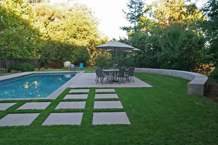 This is an example of an expansive transitional sloped partial sun formal garden for summer in San Francisco with a water feature and concrete pavers.