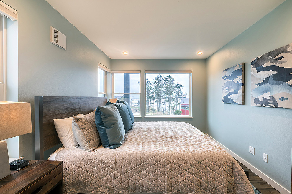 Photo of a mid-sized beach style guest bedroom in Seattle with blue walls, medium hardwood floors and brown floor.