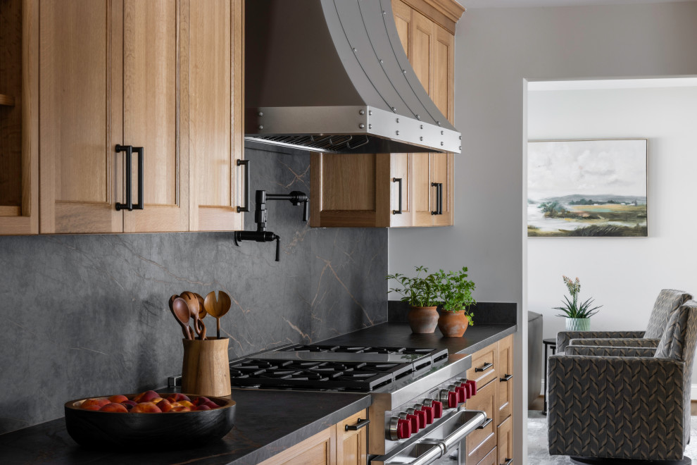 Large mountain style galley medium tone wood floor enclosed kitchen photo in DC Metro with recessed-panel cabinets, medium tone wood cabinets, quartz countertops, black backsplash, quartz backsplash, stainless steel appliances, no island and black countertops