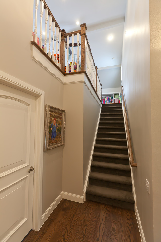 This is an example of a mid-sized traditional carpeted straight staircase in Denver with carpet risers.