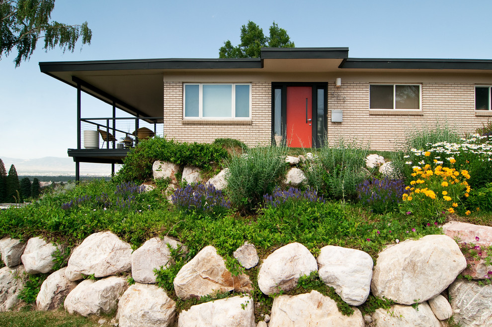 Midcentury sloped garden in Salt Lake City with a retaining wall.