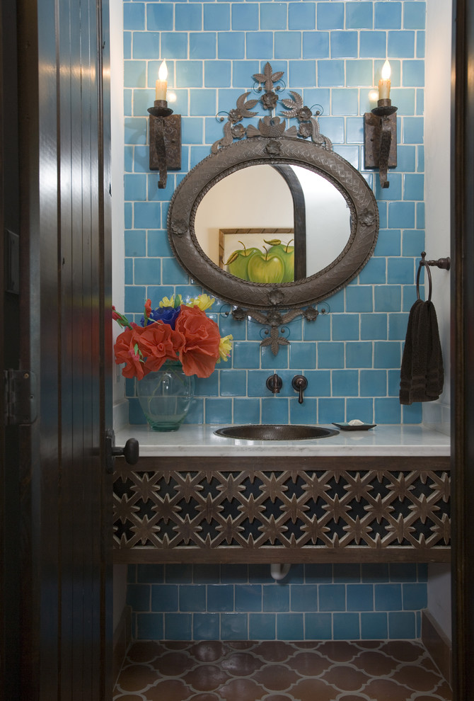 This is an example of a mediterranean bathroom in Houston with a drop-in sink and blue tile.