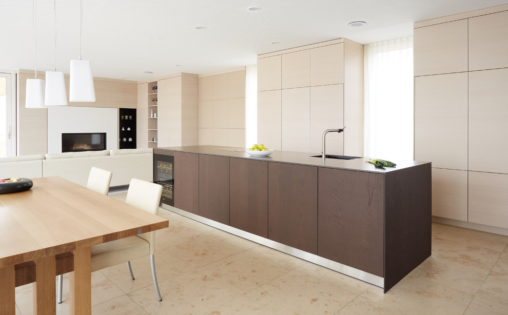 Design ideas for a large modern galley eat-in kitchen in Stuttgart with flat-panel cabinets, black appliances, with island, beige floor and light wood cabinets.
