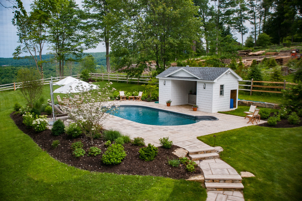 Inspiration for a mid-sized country backyard custom-shaped pool in Boston with a pool house and concrete pavers.