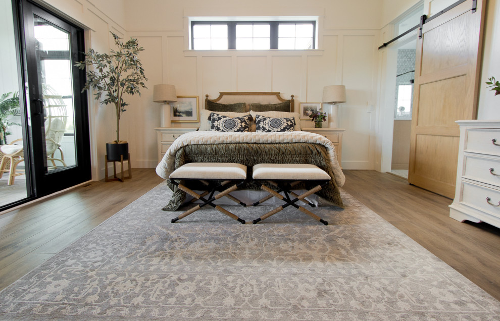 Imagen de dormitorio principal y blanco y madera de estilo de casa de campo con paredes blancas, suelo vinílico, suelo marrón y boiserie