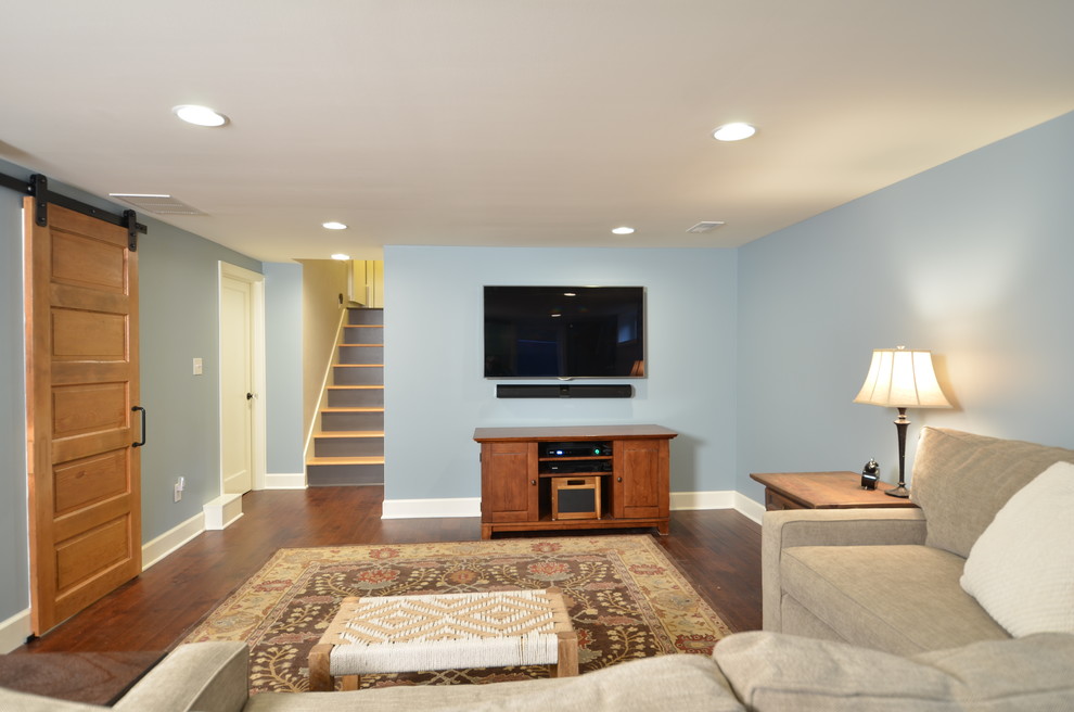 Photo of a mid-sized traditional look-out basement in Portland with blue walls and dark hardwood floors.