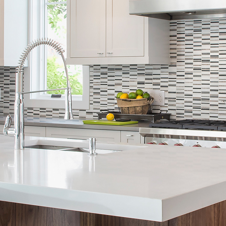Inspiration for a mid-sized transitional l-shaped dark wood floor eat-in kitchen remodel in Toronto with a double-bowl sink, shaker cabinets, white cabinets, solid surface countertops, multicolored backsplash, mosaic tile backsplash, stainless steel appliances and an island