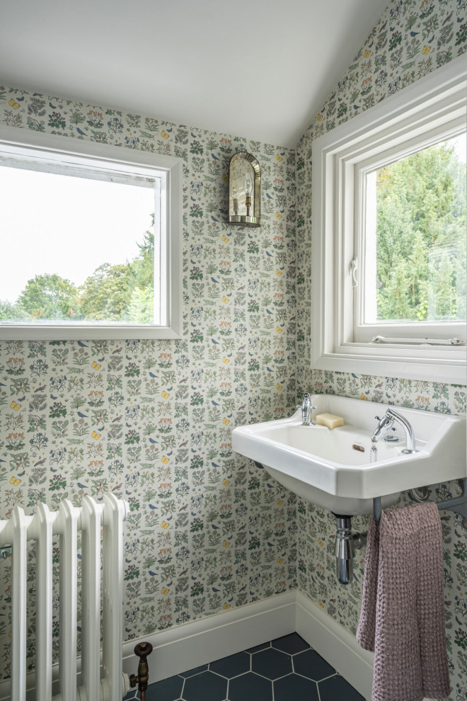 Design ideas for a small traditional bathroom in Buckinghamshire with multi-coloured walls, ceramic flooring, black floors, a single sink and wallpapered walls.