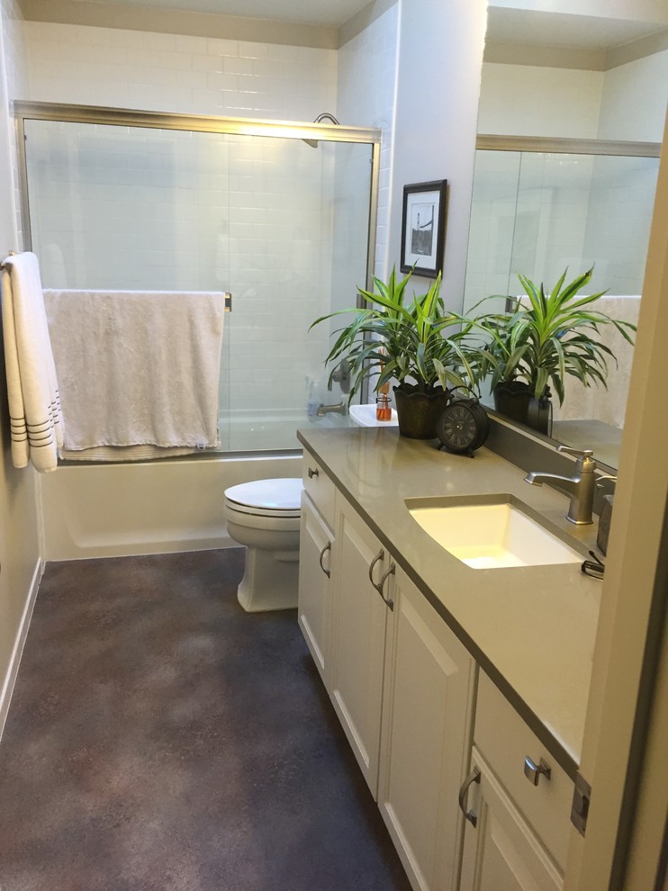 Inspiration for a mid-sized transitional kids bathroom in Seattle with an undermount sink, raised-panel cabinets, white cabinets, engineered quartz benchtops, an alcove tub, a shower/bathtub combo, a two-piece toilet, white tile, cement tile, grey walls and vinyl floors.