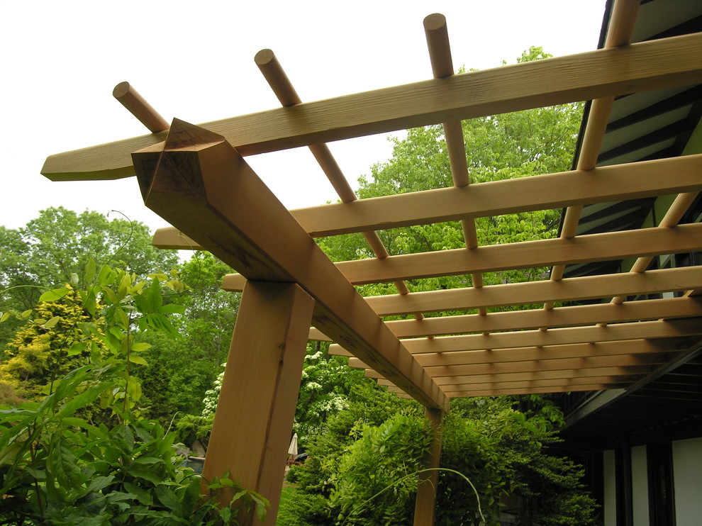 This is an example of a large asian backyard patio in Philadelphia with a pergola.