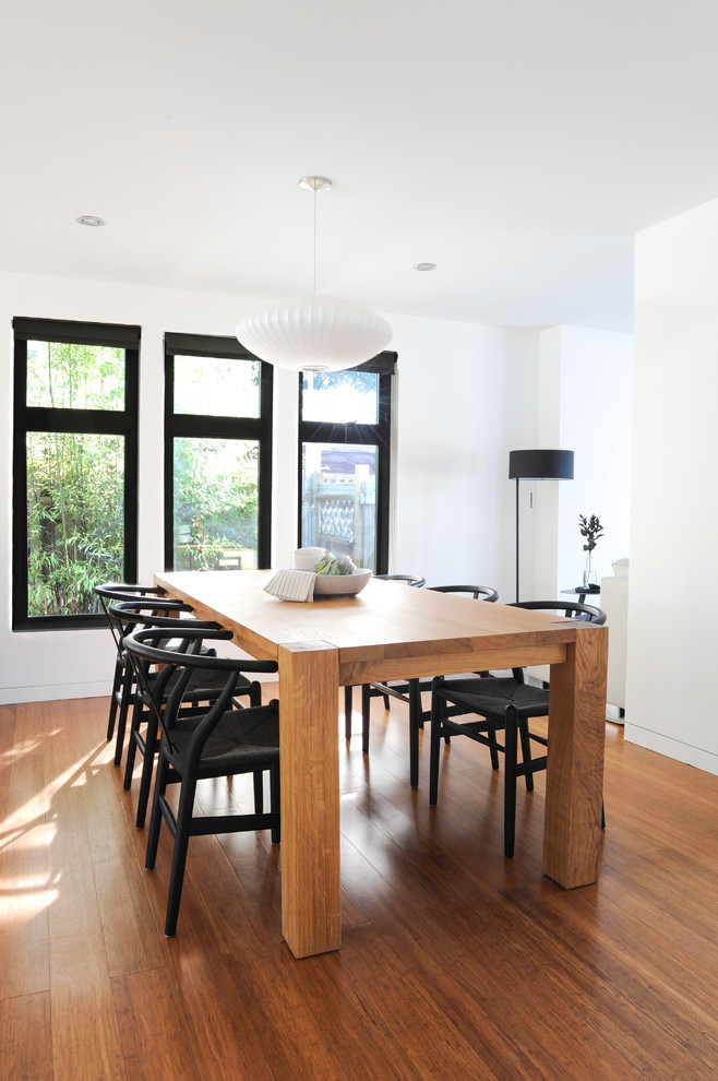 Inspiration for a contemporary dining room in Vancouver with white walls, medium hardwood floors and brown floor.