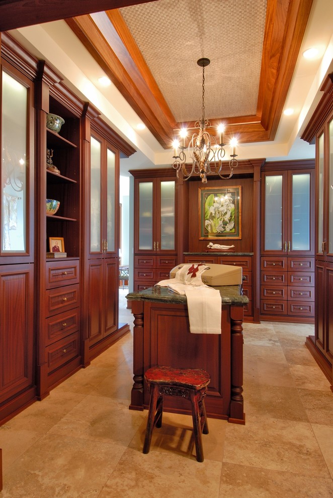 Design ideas for a traditional dressing room in Hawaii with dark wood cabinets and travertine floors.