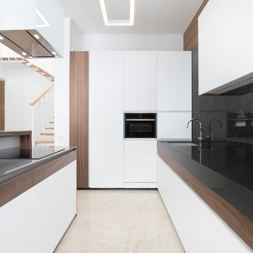 This is an example of a mid-sized contemporary l-shaped eat-in kitchen in Moscow with a single-bowl sink, white cabinets, solid surface benchtops, black splashback, marble splashback, panelled appliances, with island and black benchtop.