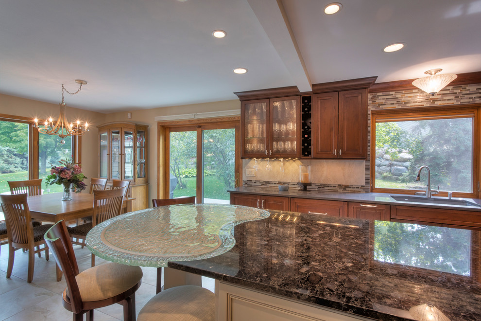 Eat-in kitchen - large transitional l-shaped ceramic tile eat-in kitchen idea with an undermount sink, raised-panel cabinets, medium tone wood cabinets, glass countertops, multicolored backsplash, mosaic tile backsplash, paneled appliances and an island