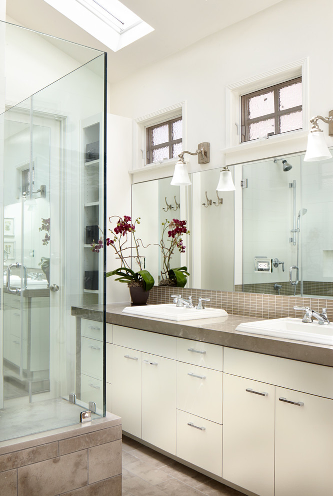 Inspiration for a small transitional bathroom in Los Angeles with a drop-in sink, flat-panel cabinets and white cabinets.