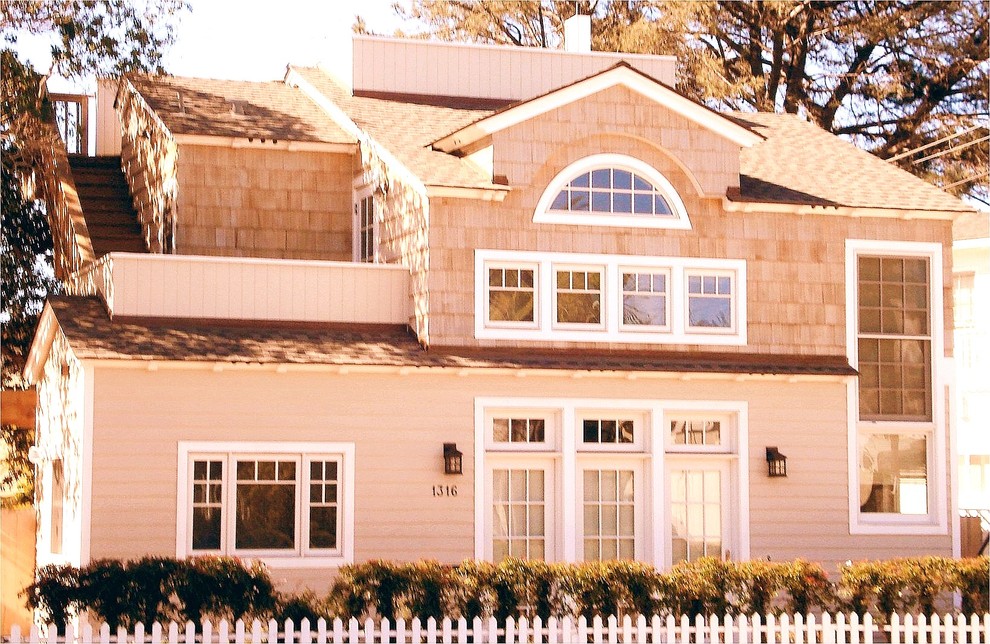 Mid-sized beach style two-storey beige house exterior in San Diego with wood siding, a gable roof and a shingle roof.