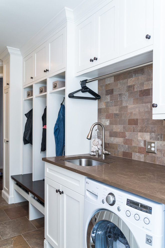 This is an example of a mid-sized traditional single-wall utility room in Detroit with an undermount sink, shaker cabinets, white cabinets, marble benchtops, beige walls, slate floors and a side-by-side washer and dryer.