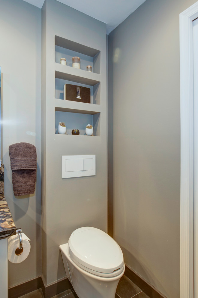 Large contemporary powder room in DC Metro with an undermount sink, flat-panel cabinets, white cabinets, a wall-mount toilet, multi-coloured tile, pebble tile, grey walls and ceramic floors.
