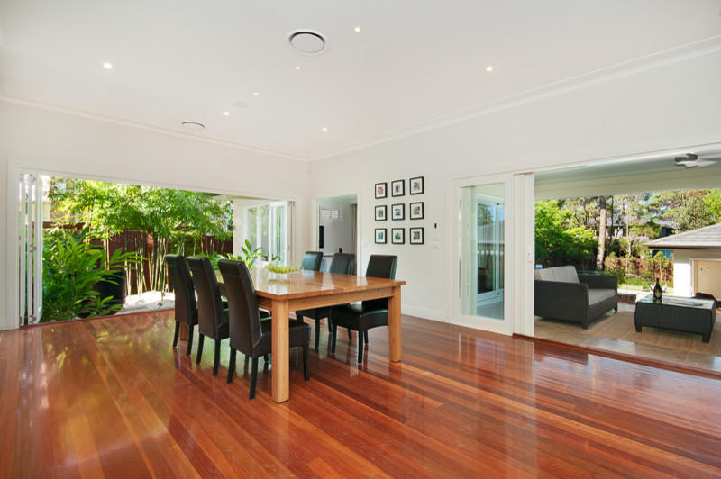 Photo of a large contemporary open plan dining in Sydney with white walls and medium hardwood floors.