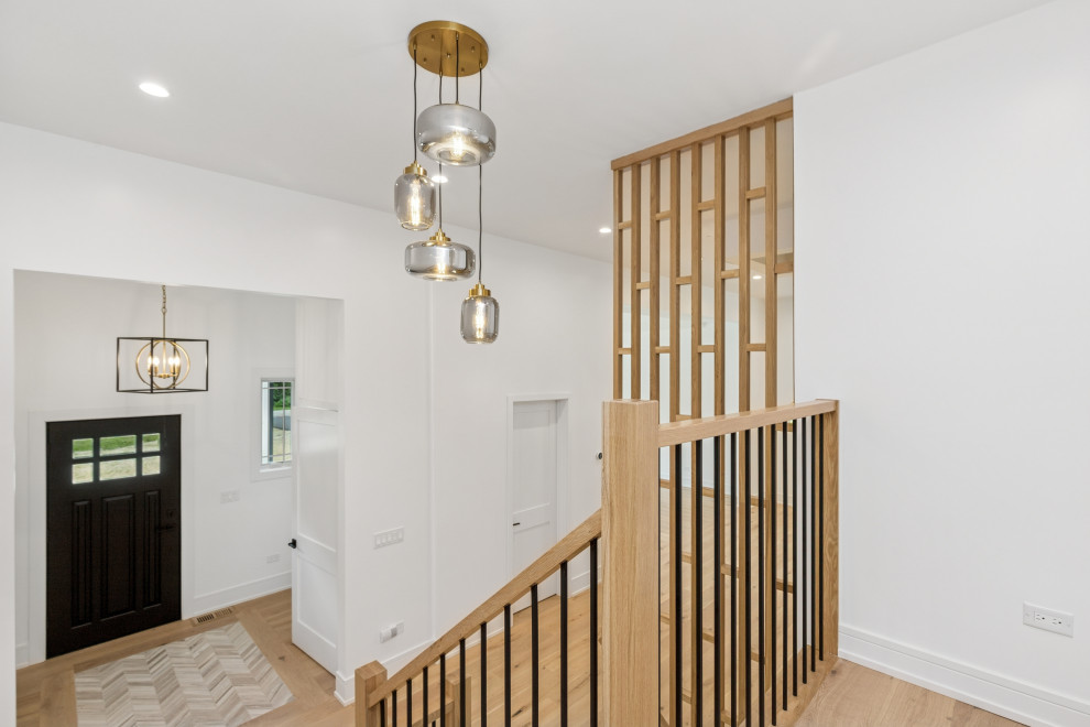 Modern Foyer with Vertical Slat Divider and Layered Pendant Lighting