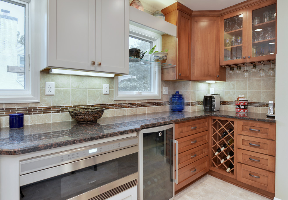 Example of a transitional l-shaped kitchen design in Milwaukee with shaker cabinets, medium tone wood cabinets, beige backsplash and stainless steel appliances