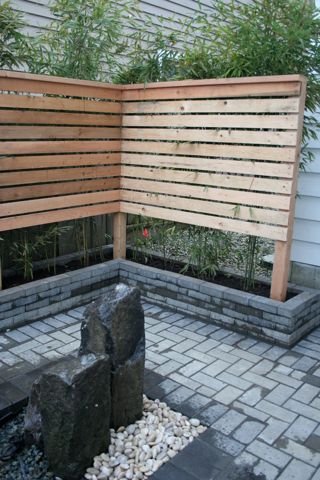 Design ideas for a mid-sized asian backyard shaded garden in Vancouver with a water feature and brick pavers.