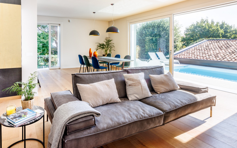 Foto di un soggiorno design di medie dimensioni e aperto con pareti bianche e pavimento in legno verniciato