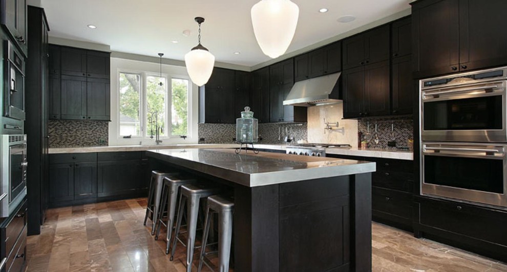 Photo of a mid-sized contemporary u-shaped eat-in kitchen in Sacramento with dark wood cabinets, stainless steel benchtops, light hardwood floors, with island, an undermount sink, shaker cabinets, metallic splashback, matchstick tile splashback, stainless steel appliances and multi-coloured floor.