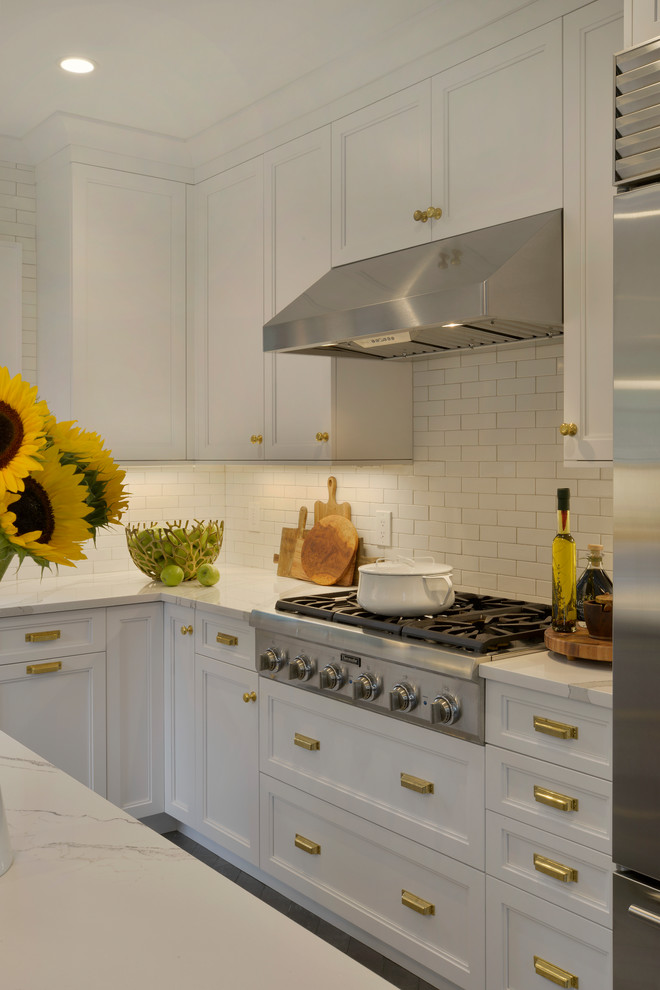 Inspiration for a small transitional u-shaped porcelain tile and gray floor enclosed kitchen remodel in New York with an undermount sink, recessed-panel cabinets, white cabinets, quartz countertops, white backsplash, ceramic backsplash, stainless steel appliances, an island and white countertops