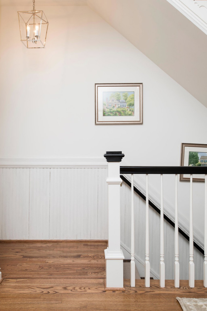 This is an example of a traditional carpeted straight wood railing staircase in Baltimore with wainscoting and a dado rail.