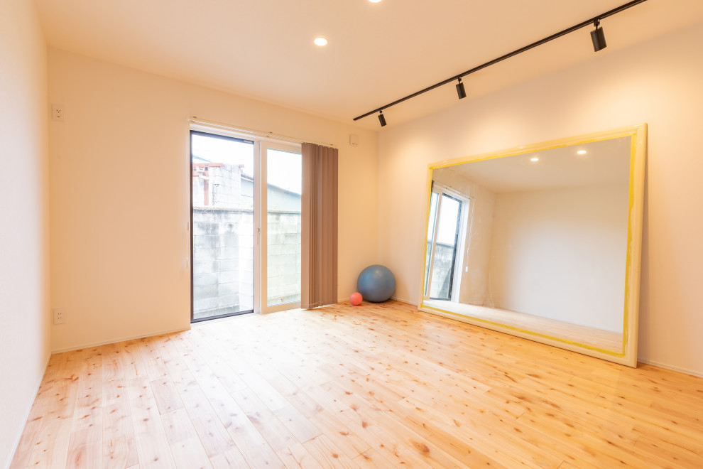 Inspiration for a home yoga studio in Other with white walls and beige floor.