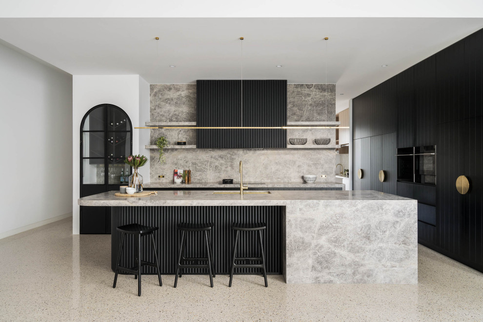 Photo of a large contemporary l-shaped open plan kitchen in Melbourne with a double-bowl sink, black cabinets, marble worktops, grey splashback, marble splashback, black appliances, concrete flooring, an island, grey floors and grey worktops.