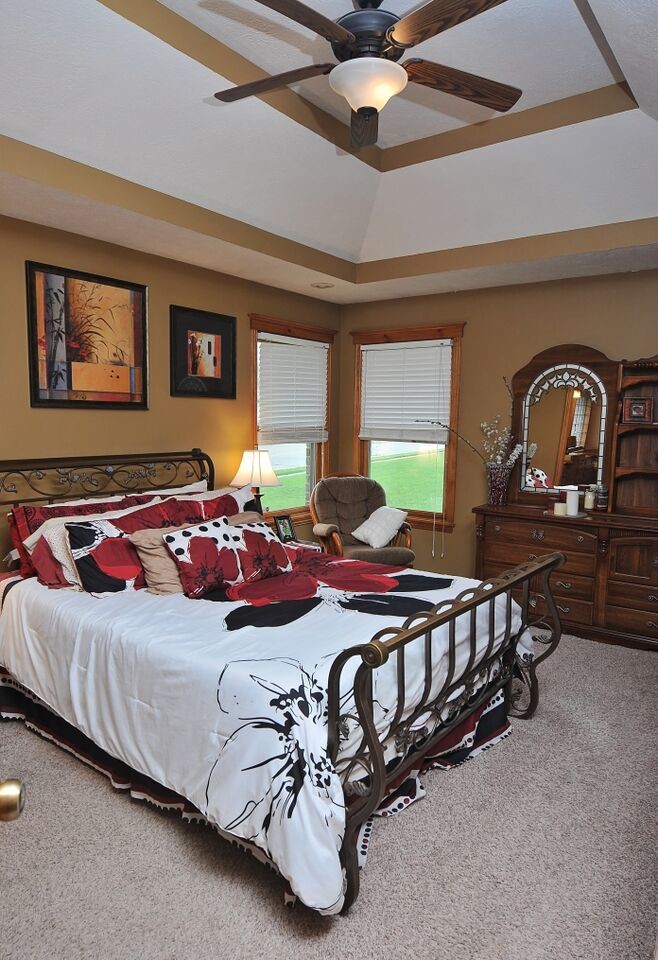 Transitional master carpeted bedroom photo with brown walls