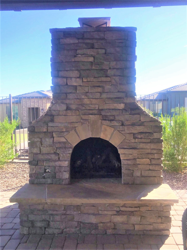 Large transitional backyard concrete paver patio photo in Phoenix with a fireplace