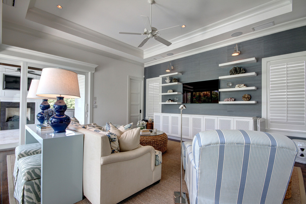 This is an example of a large beach style open concept family room in Tampa with white walls, medium hardwood floors, no fireplace and a wall-mounted tv.