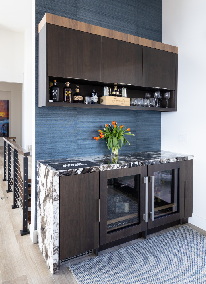 Small modern single-wall home bar with flat-panel cabinets, dark wood cabinets, granite benchtops, blue splashback, porcelain floors, brown floor and multi-coloured benchtop.