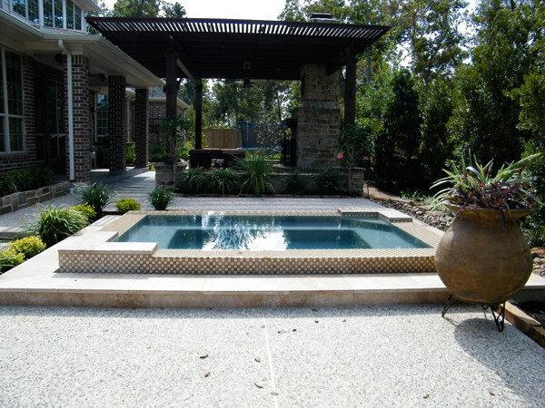 Mid-sized transitional backyard concrete and rectangular hot tub photo in Houston