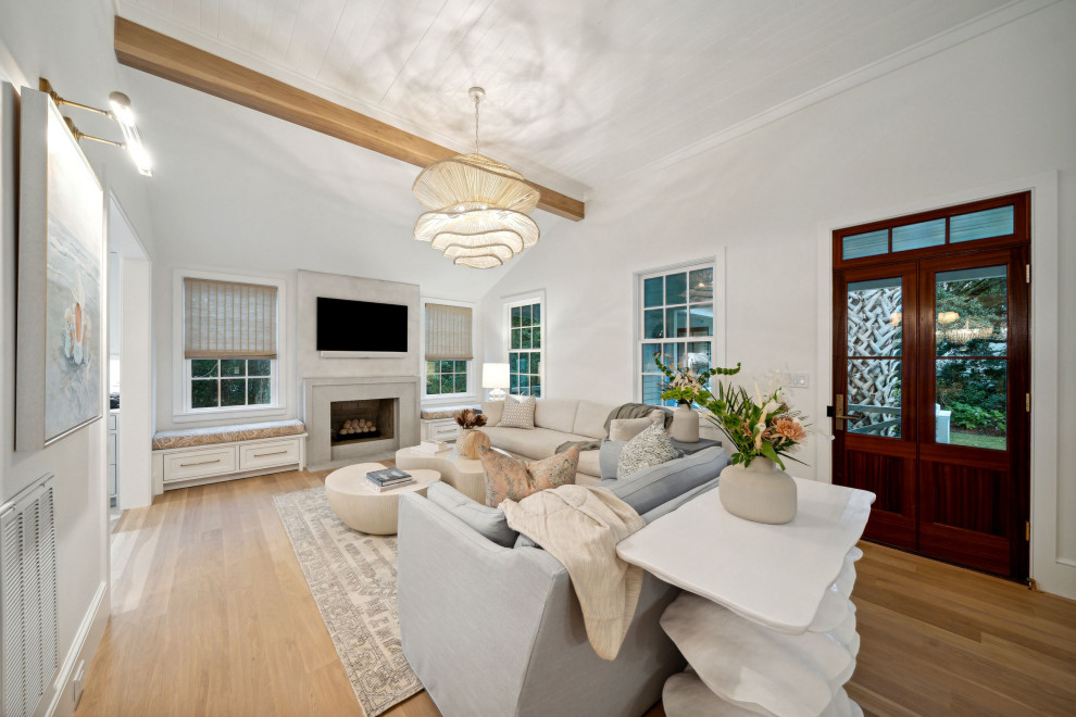 This is an example of a nautical living room in Charleston with white walls, light hardwood flooring, a standard fireplace, a concrete fireplace surround and a wood ceiling.