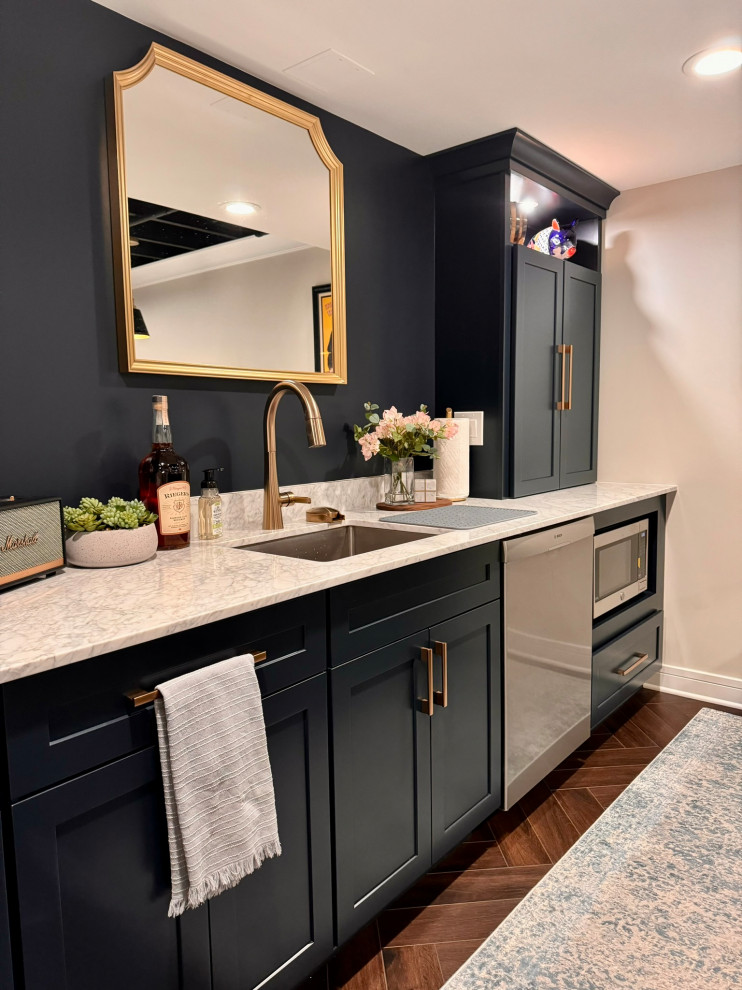 Medium sized traditional galley wet bar in Detroit with a submerged sink, shaker cabinets, blue cabinets, marble worktops, white splashback, marble splashback, vinyl flooring, brown floors and white worktops.