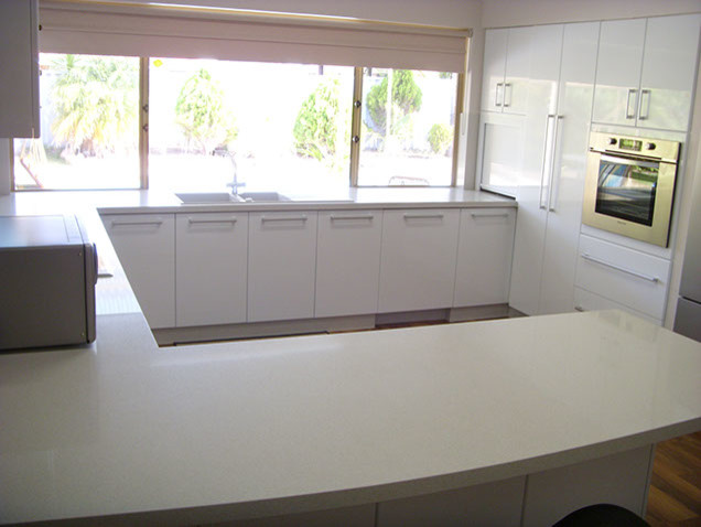Design ideas for a contemporary u-shaped eat-in kitchen in Perth with a double-bowl sink, flat-panel cabinets, white cabinets, granite benchtops, white splashback, stone slab splashback, stainless steel appliances, medium hardwood floors and no island.